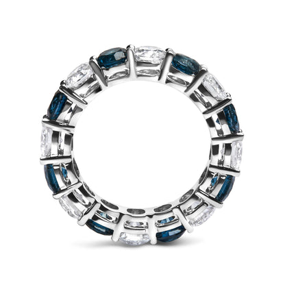 Top-down close-up of a white metal ring with alternating round blue and white gemstones set in shared prong settings, shown against a white background.