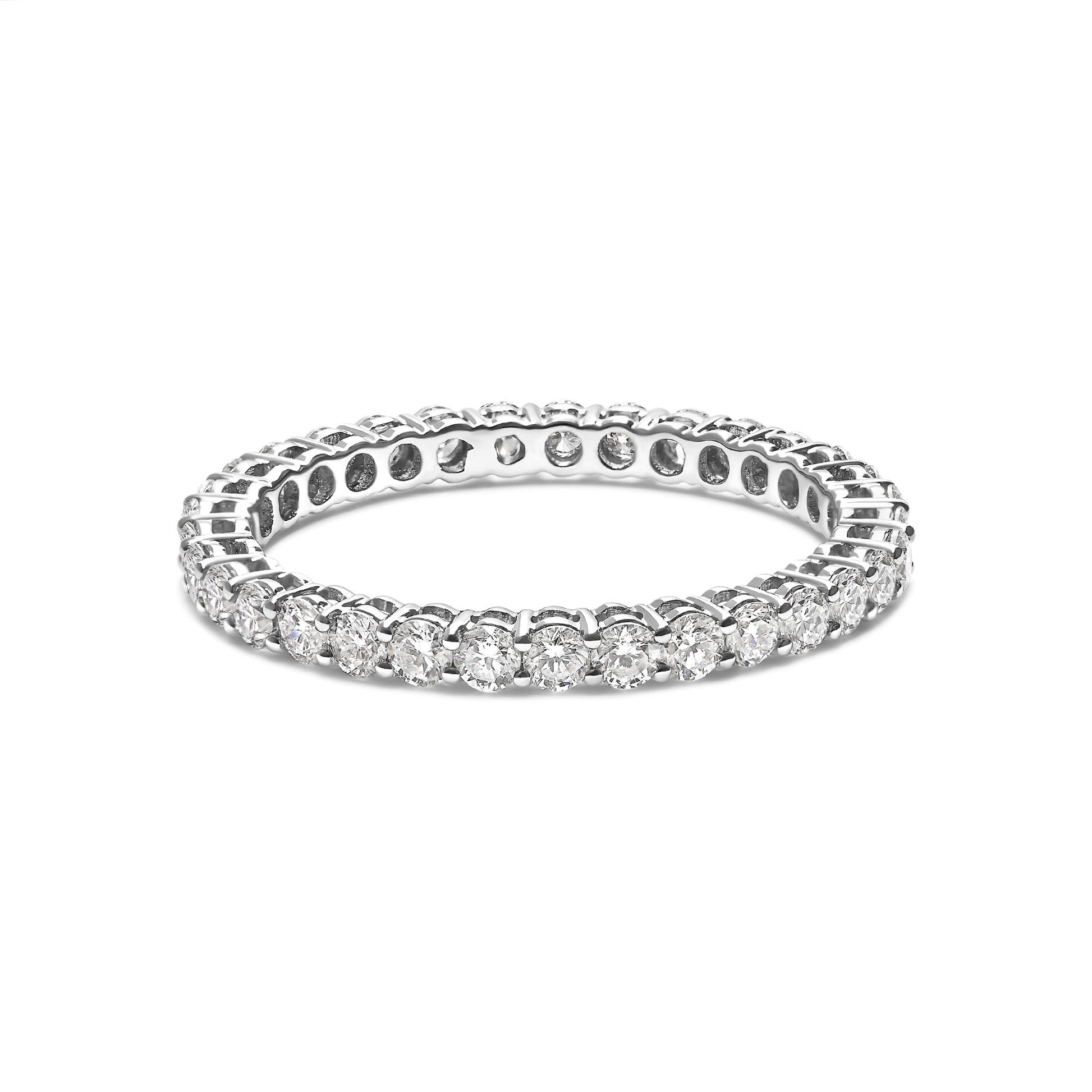 White metal ring with round white gemstones in shared prong setting, shown at a slight angle on a white background.