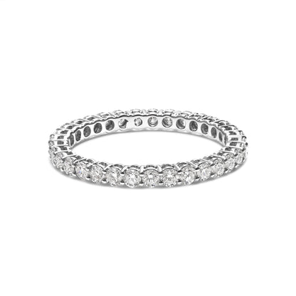 White metal ring with round white gemstones in shared prong setting, shown at a slight angle on a white background.