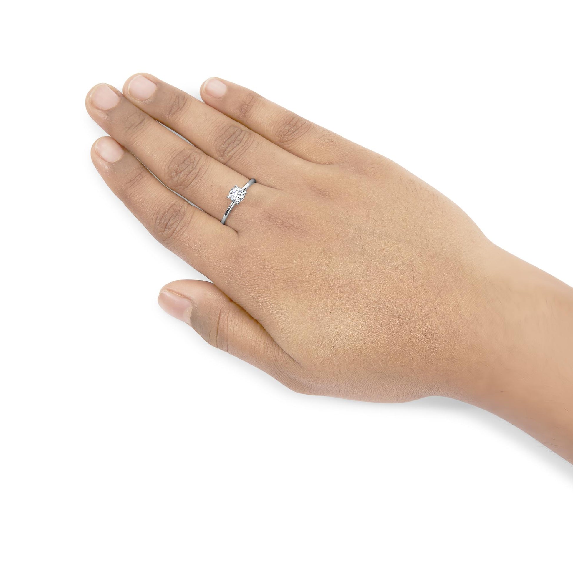 White metal ring with a single round white gemstone in a four-prong setting, shown on a model's hand from a top angle.