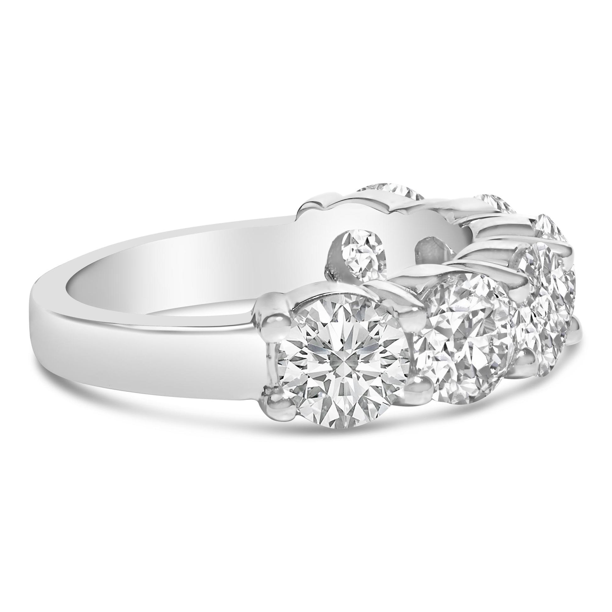 Close-up front angled view of a white metal ring featuring six round white gemstones in a shared prong setting.