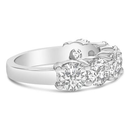 Close-up front angled view of a white metal ring featuring six round white gemstones in a shared prong setting.