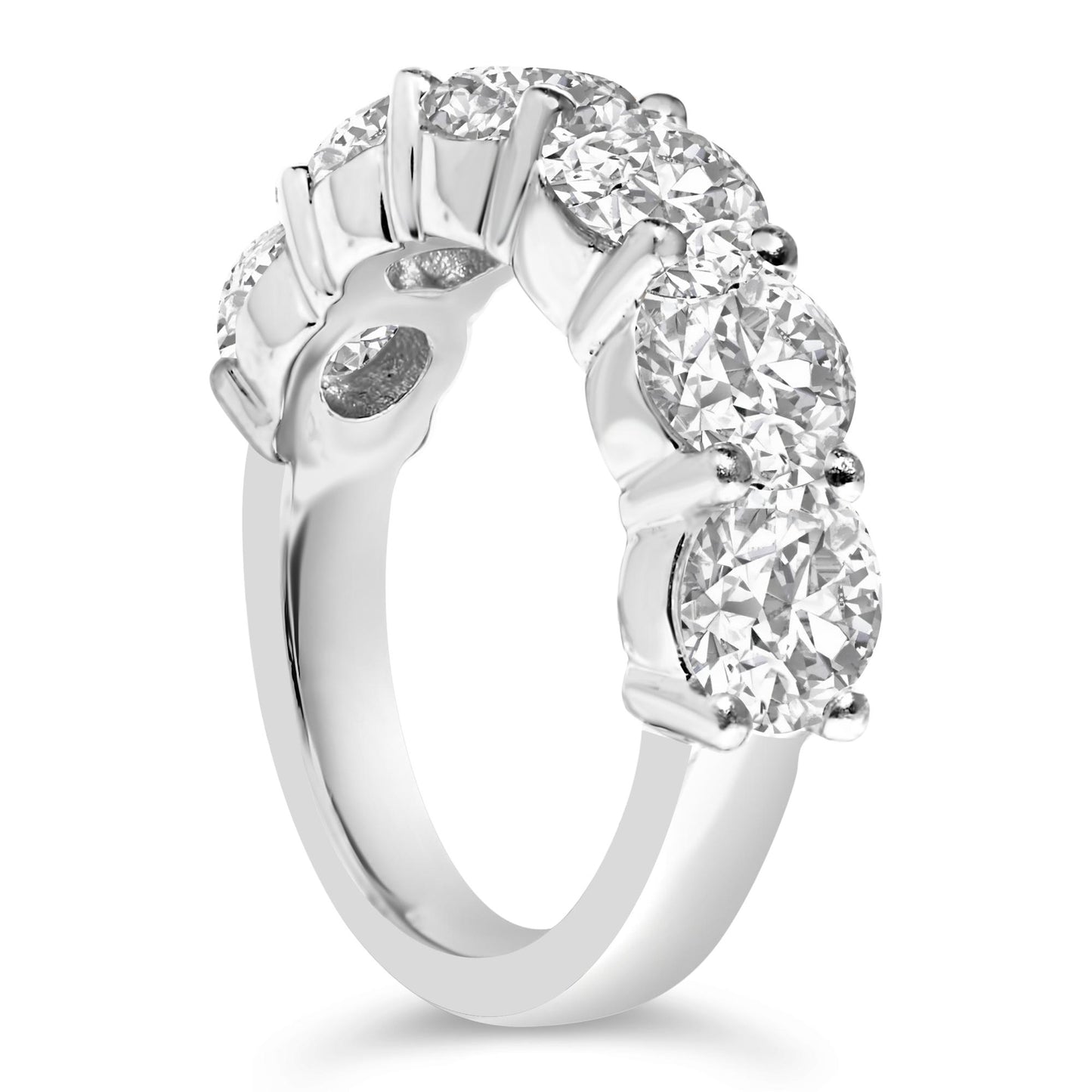 Close-up angled side view of a white metal ring featuring six round white gemstones in a shared prong setting.