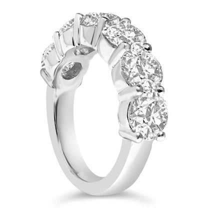 Close-up angled side view of a white metal ring featuring six round white gemstones in a shared prong setting.