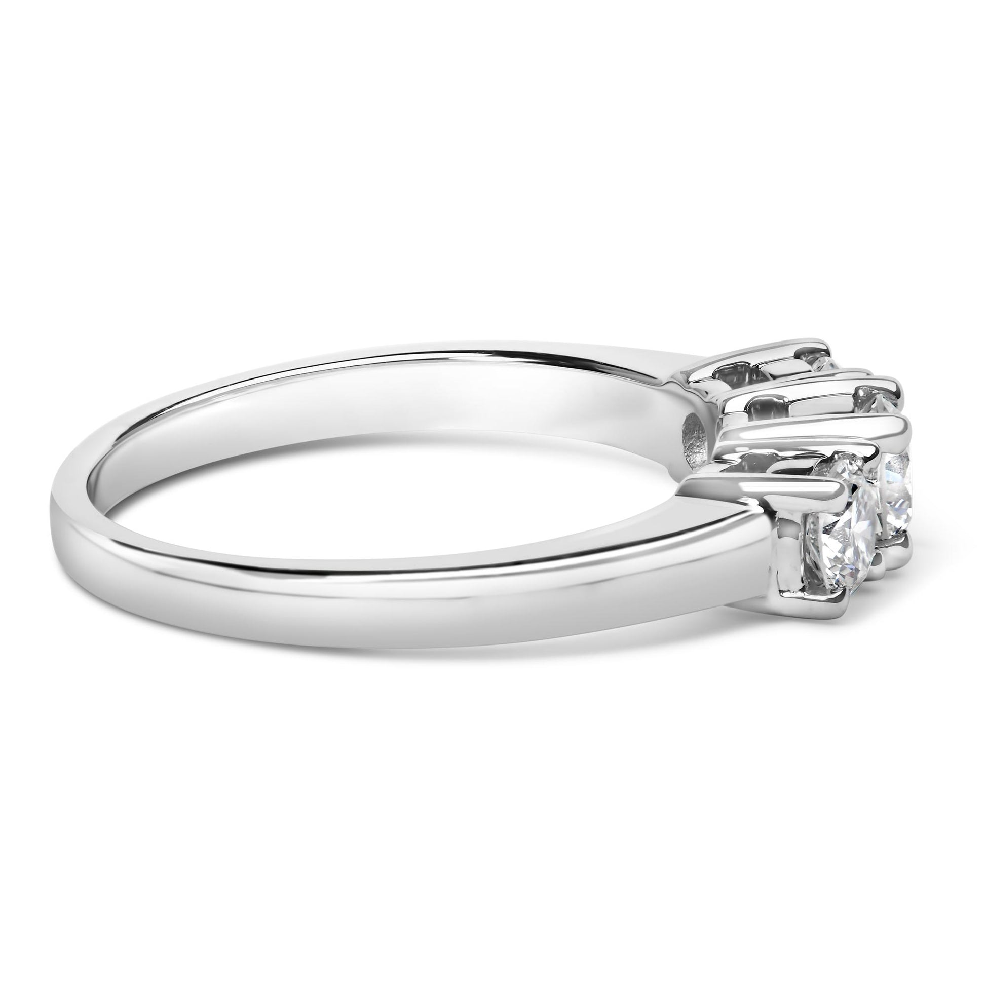 Side angle view of a white metal ring featuring three round white gemstones set in 4-prong settings.