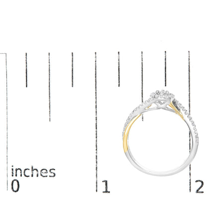Top-down view of a two-tone ring with a cluster of round white gemstones at the center and additional gemstones along the band, placed on a ruler for size reference.