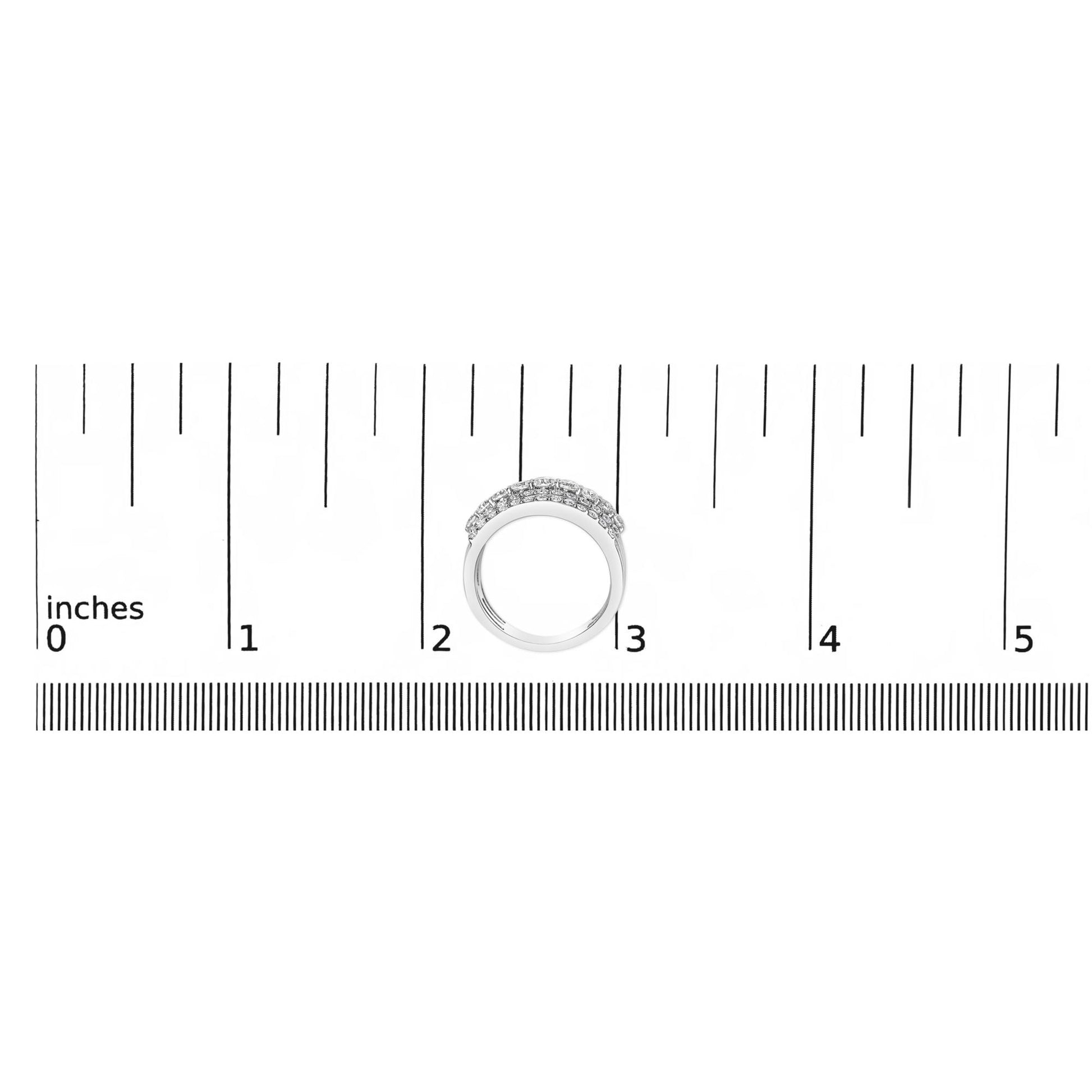 White metal ring with a gently curved band featuring multiple small white gemstones set in prongs, shown from above on a ruler scale.