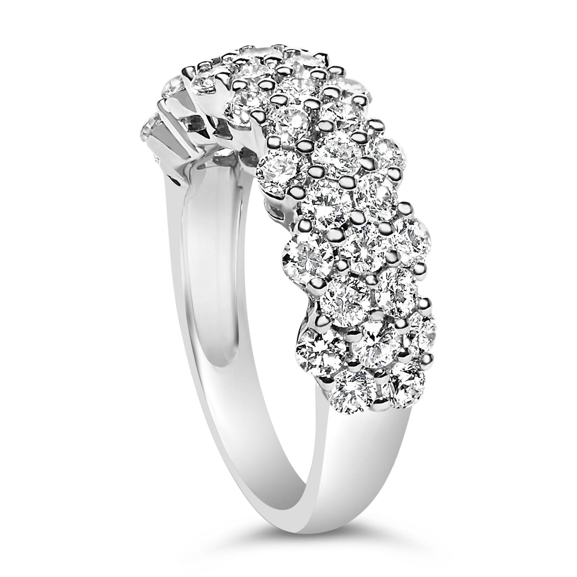 White metal ring with clusters of round white gemstones in prong settings, shown from a side angle.