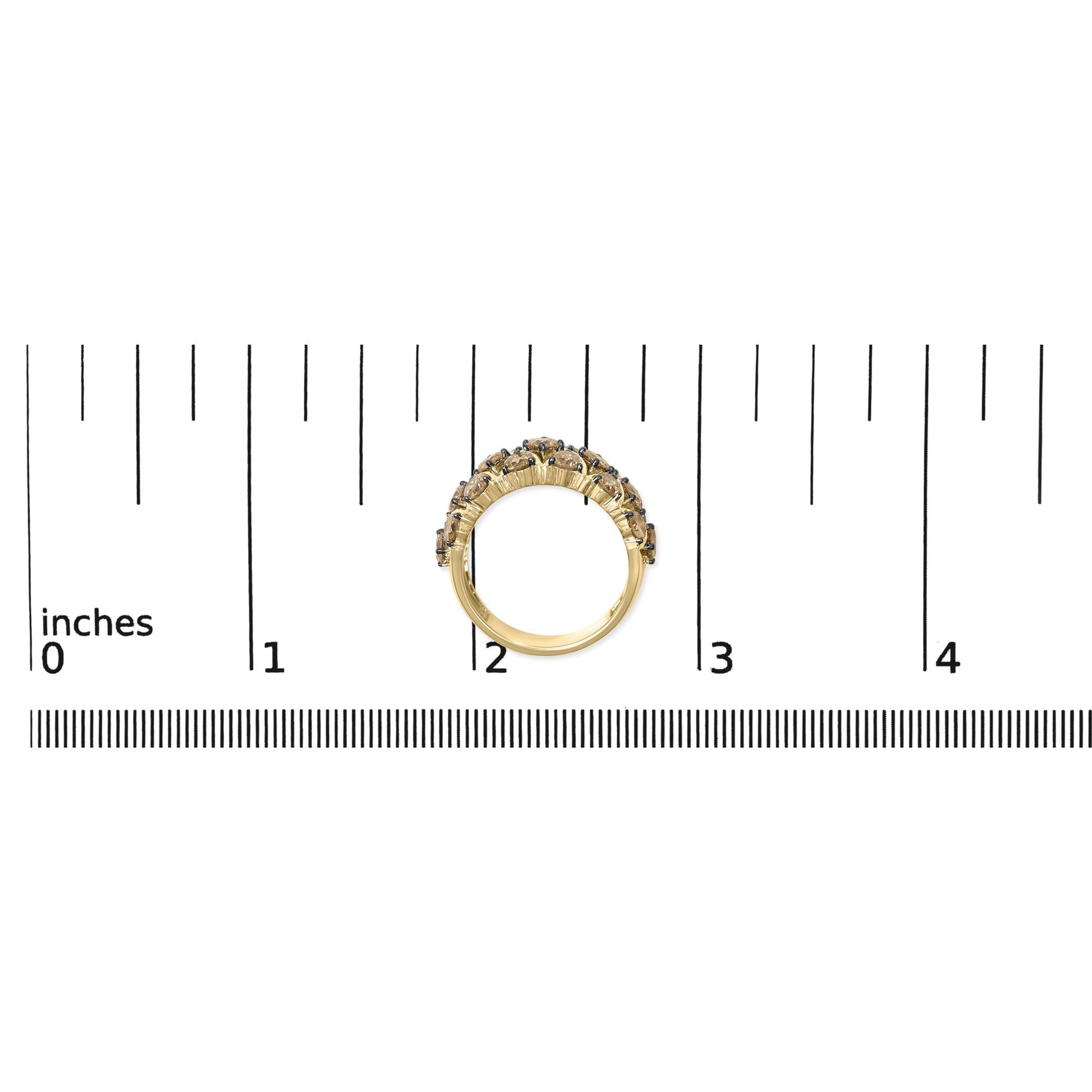 Yellow metal ring with two rows of round champagne-colored gemstones in prong settings, shown from the side on a scale.