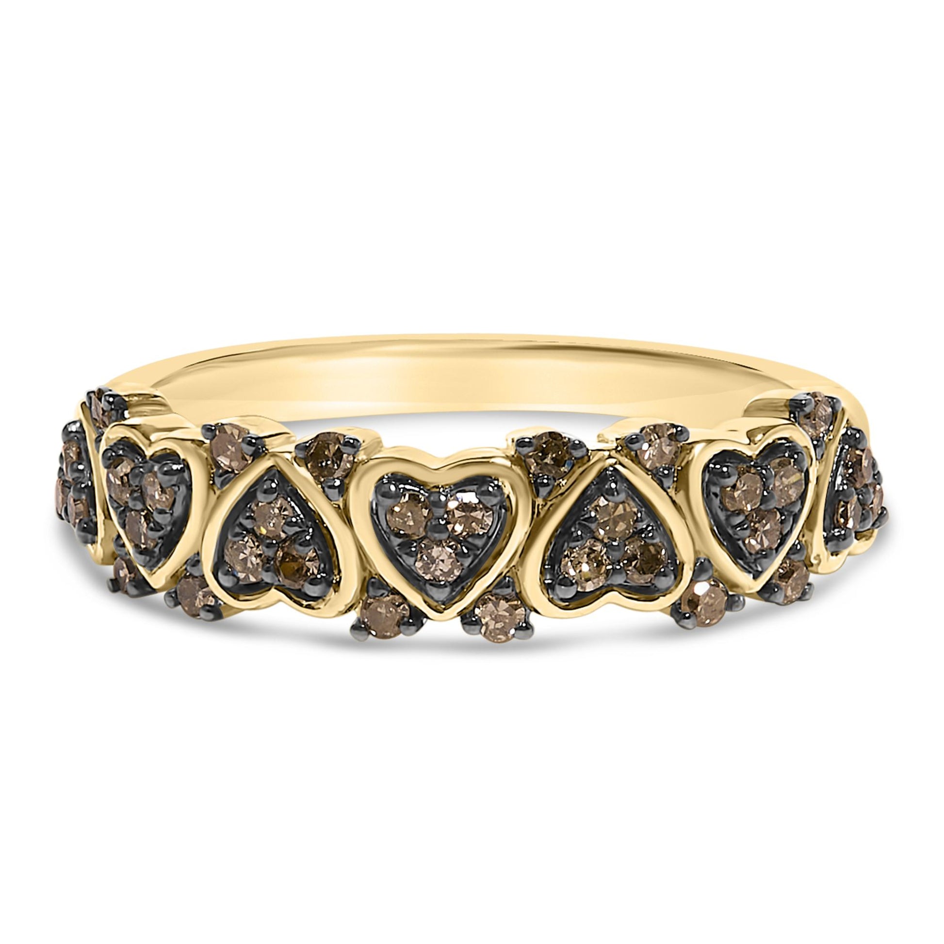 Front-facing shot of a yellow metal ring featuring alternating heart and teardrop shapes, each set with round champagne-colored gemstones in prong settings.