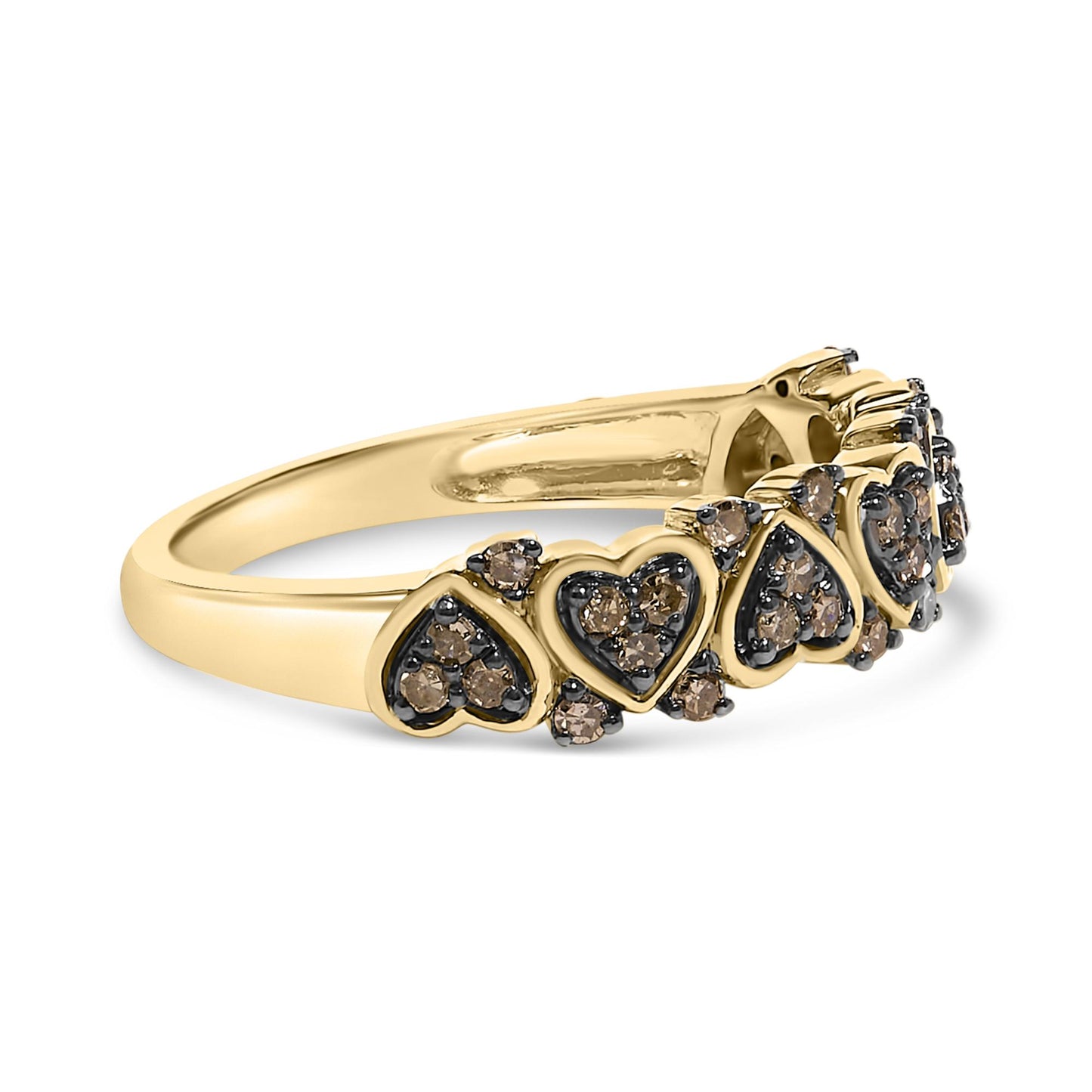 Close-up angled side view of a yellow metal ring featuring multiple heart-shaped motifs set with round champagne-colored gemstones in prong settings.