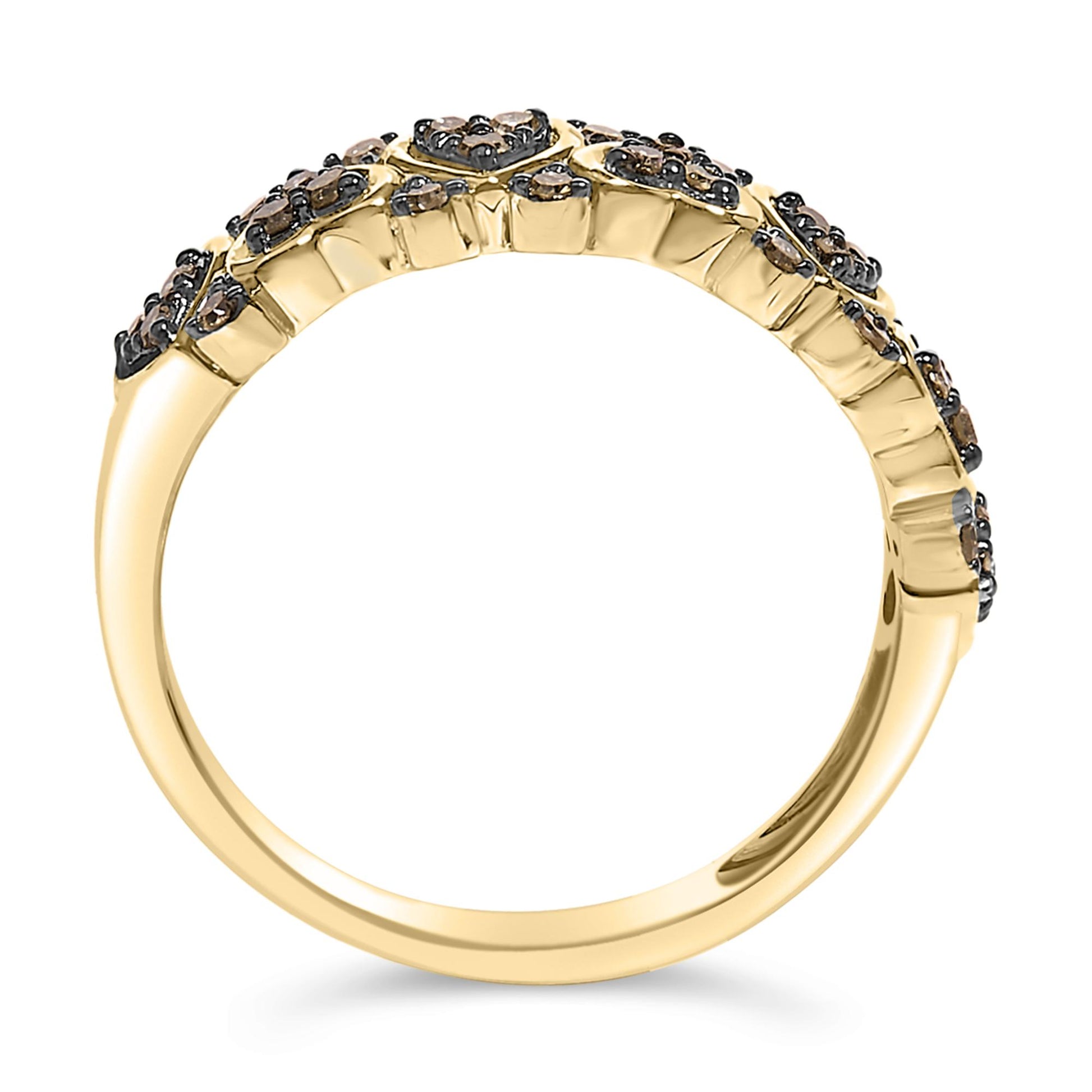 Close-up side view of a yellow metal ring adorned with clusters of small round champagne-colored gemstones in prong settings along the top half.