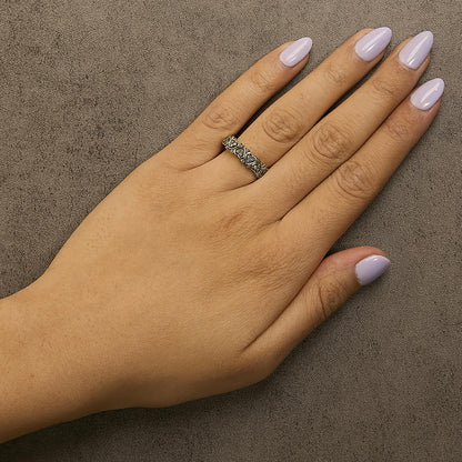 Yellow metal ring with heart-shaped design and round champagne-colored gemstones in prong settings, shown worn on a model's hand, top-down angle.