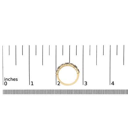 Yellow metal ring with round champagne-colored gemstones in prong settings, shown on a scale from a side angle.