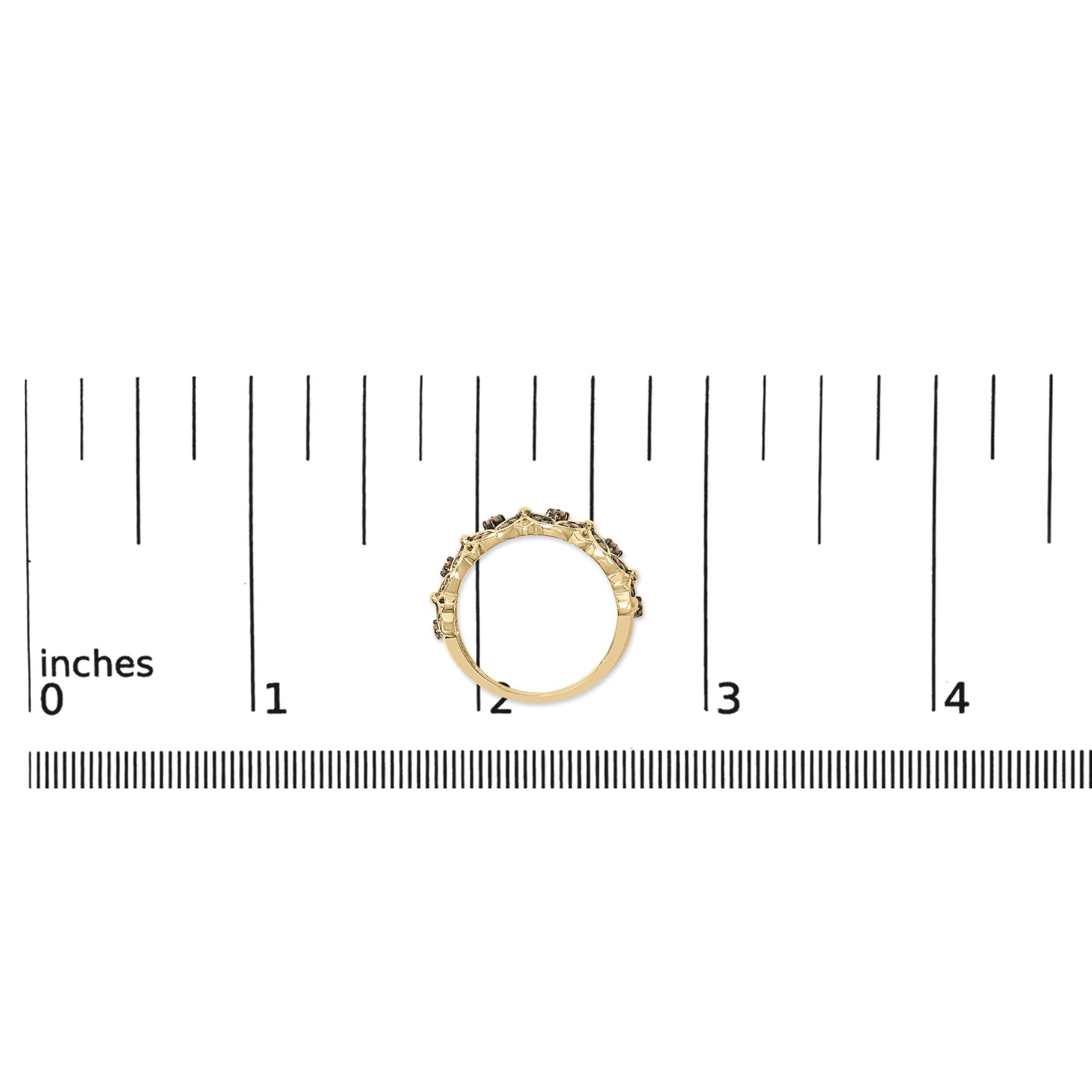 Yellow ring with round champagne-colored gemstones in prong settings, shown on a scale from a side angle.