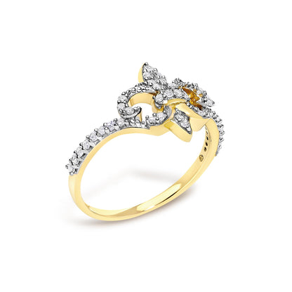 Close-up front angle of a yellow ring featuring an intricate design adorned with multiple white round gemstones in prong settings along the band and decorative elements.