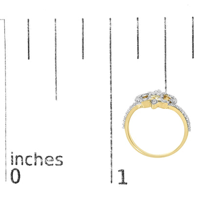 Yellow ring with round white gemstones in prong setting forming a floral pattern, shown on a scale from a side angle.