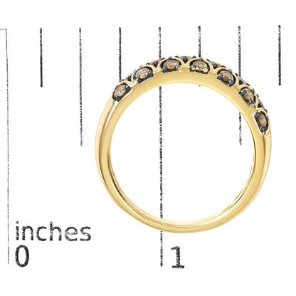 Close-up front angle of a yellow ring with round champagne-colored gemstones in prong settings, shown on a scale.