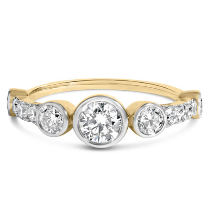 Close-up front angle of a yellow metal ring featuring round white gemstones in bezel and prong settings, displayed on a white background.