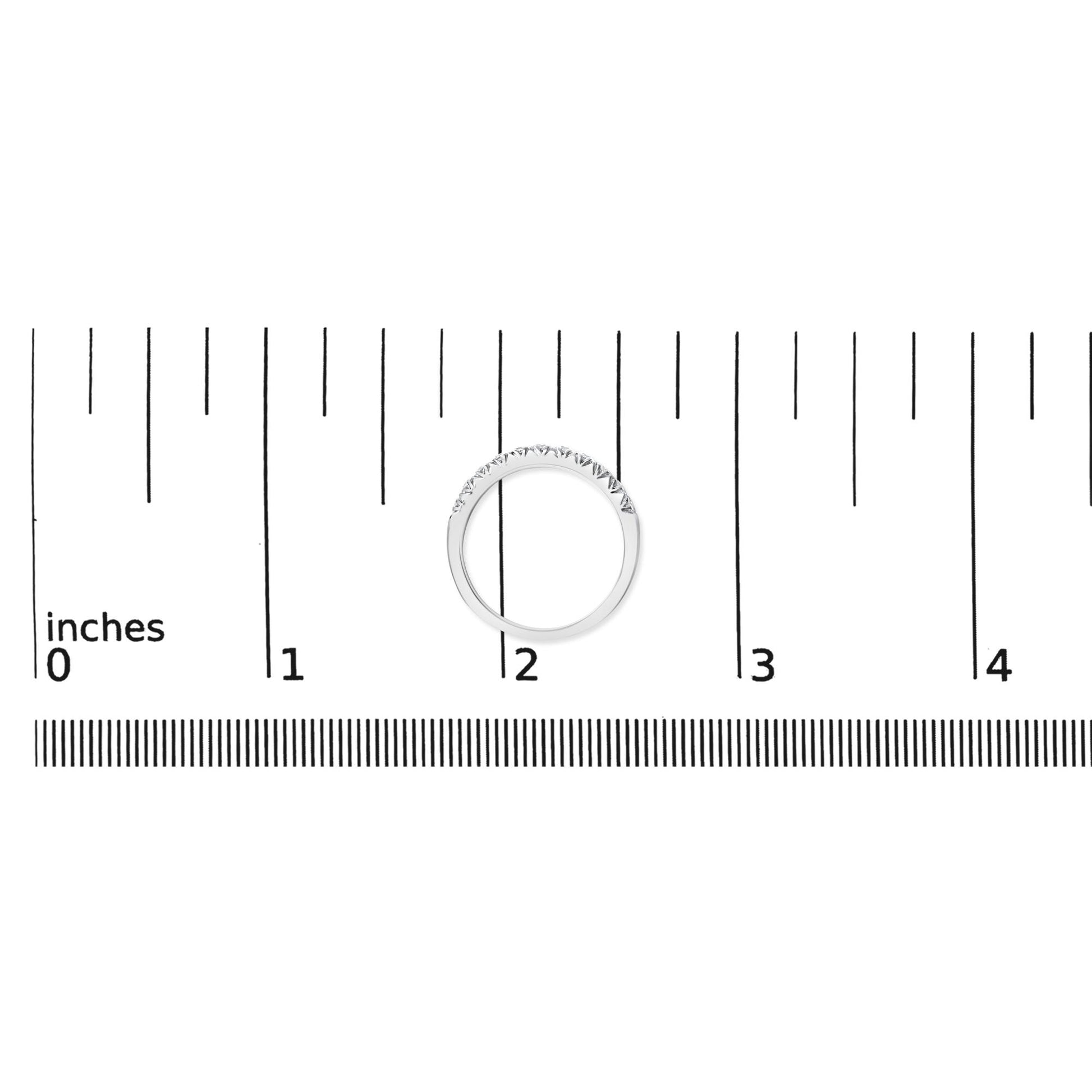 White metal ring with a row of small round white gemstones in a micro-pave setting, shown flat on a ruler scale, top-down angle.