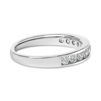 Close-up angled view of a white metal ring with round white gemstones set in a channel along the band.