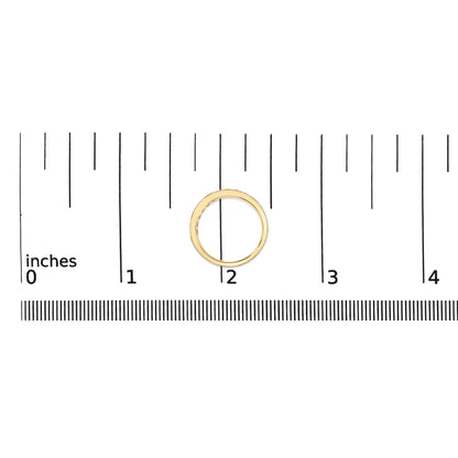 Yellow metal ring with round white gemstones set in a channel setting, shown on a scale from a top-down angle.