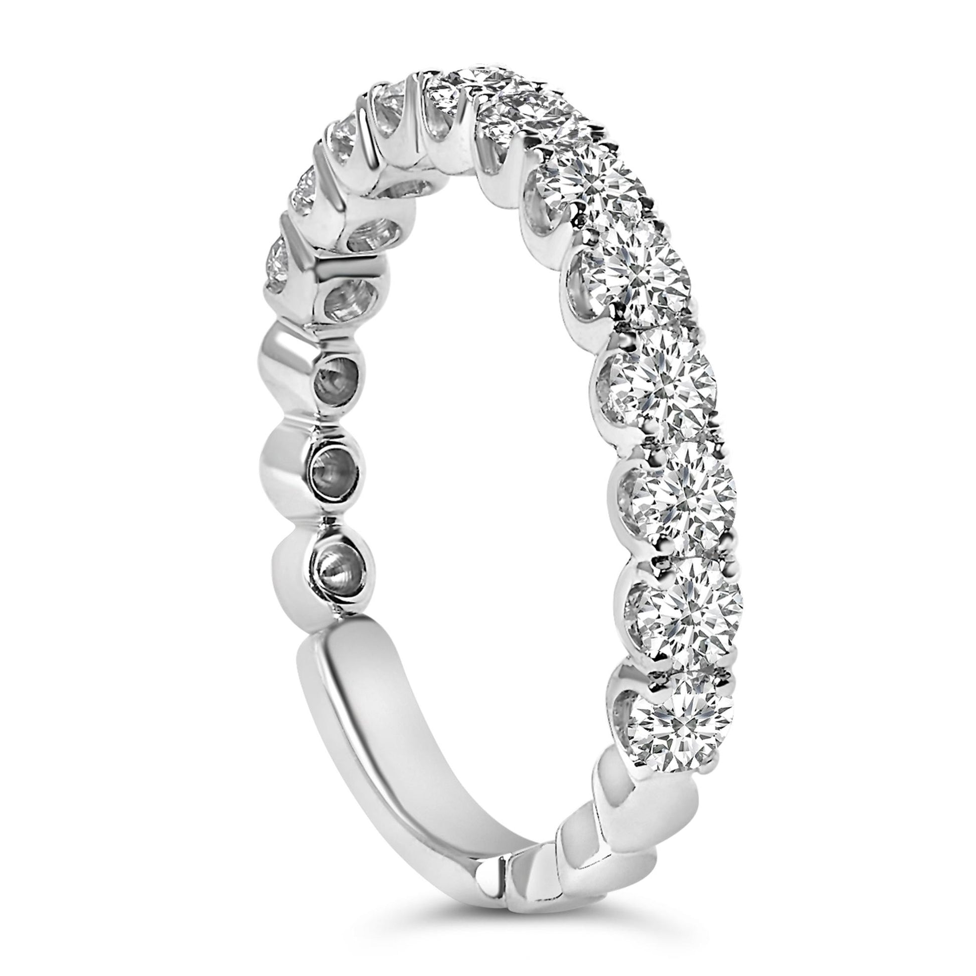Close-up side angle of a white metal ring featuring a continuous row of round white gemstones in 4-prong settings around the band.