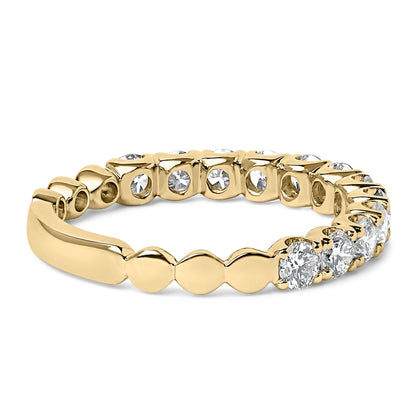 Yellow metal ring with round white gemstones in 4-prong settings around the band, shown in a close-up angled side view.