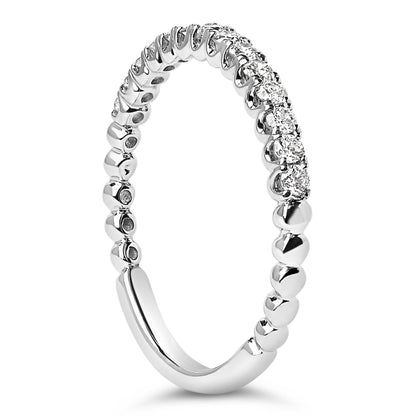 Close-up angled view of a white metal ring featuring round white gemstones in a prong setting along the top half of the band.