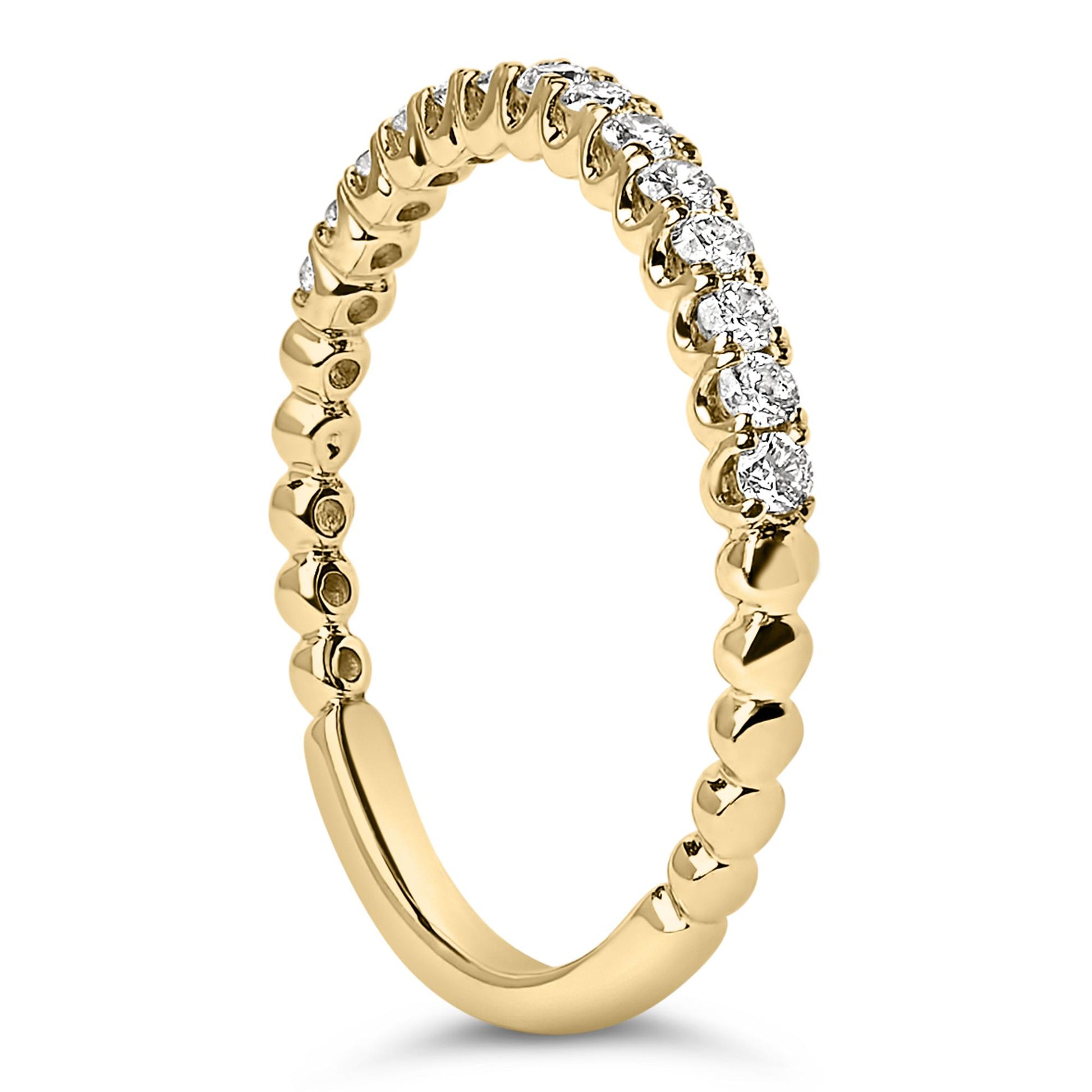 Close-up front angle of a yellow metal ring featuring a row of round white gemstones in prong settings along the upper half.