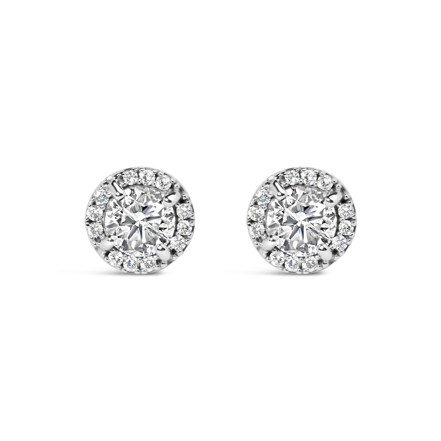 Front view of a pair of white metal stud earrings featuring a central round gemstone in a four-prong setting, surrounded by smaller round gemstones in a shared prong and channel setting.