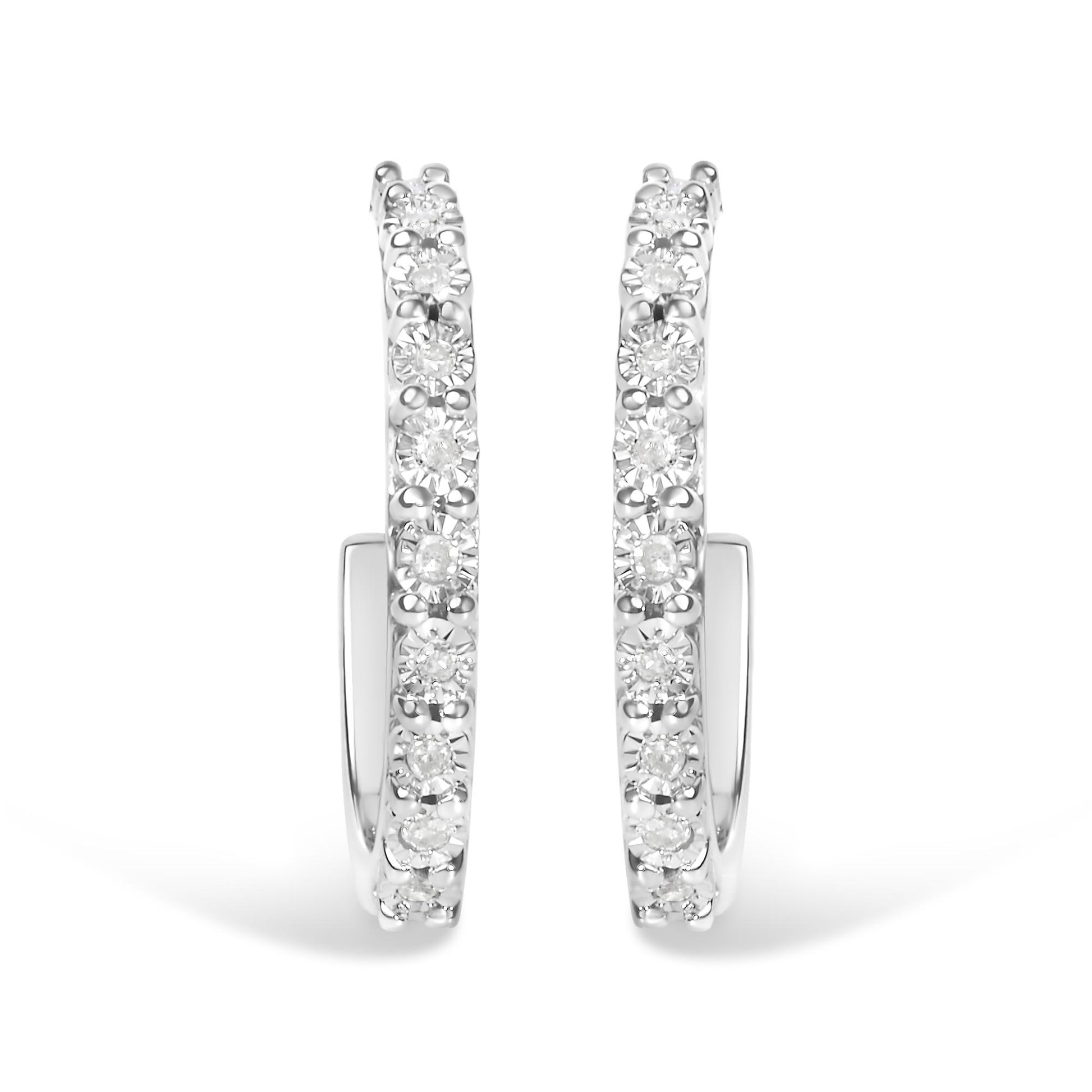 Front-facing close-up of white metal hoop earrings with round white gemstones set along the outer edge in a miracle setting.