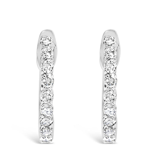 Front-facing view of white metal hoop earrings adorned with round white gemstones in a 4-prong setting along the outer edge.
