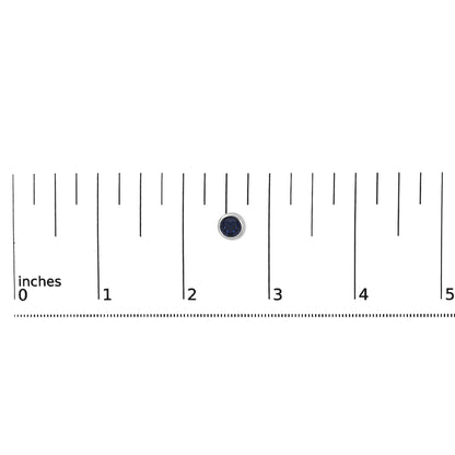 Close-up of a single round blue gemstone earring with a white metal bezel setting, shown flat on a ruler for scale.