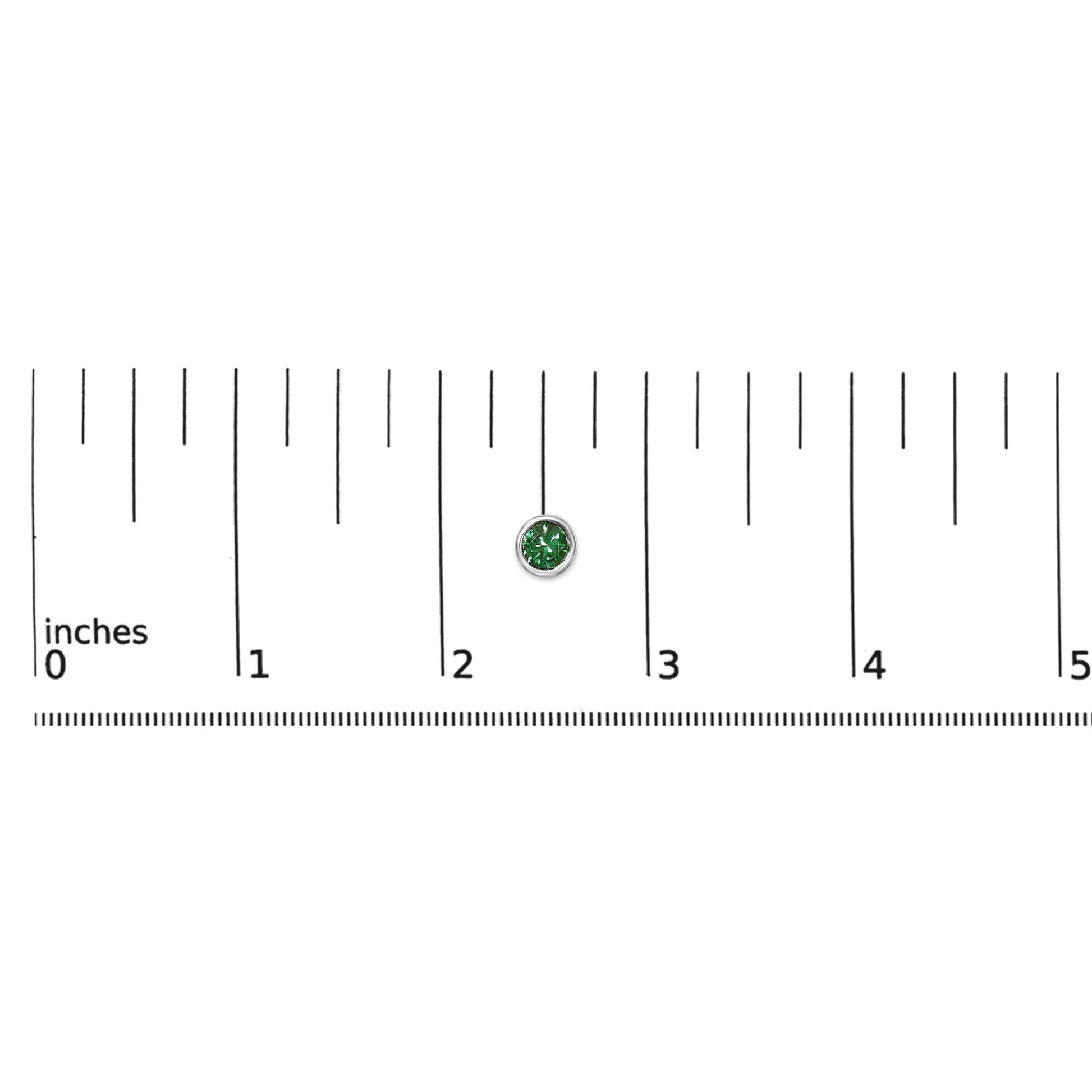 White metal earring with a round green gemstone in bezel setting, shown on a scale from above.