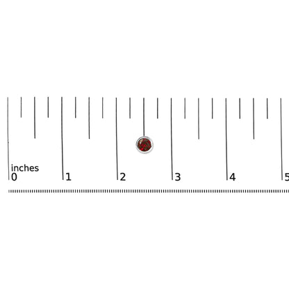 Close-up front view of a single white metal round earring with a red round gemstone in a bezel setting, shown on a scale.