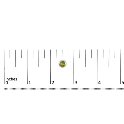 White metal round bezel-set green gemstone earring shown on a scale from a top-down angle.