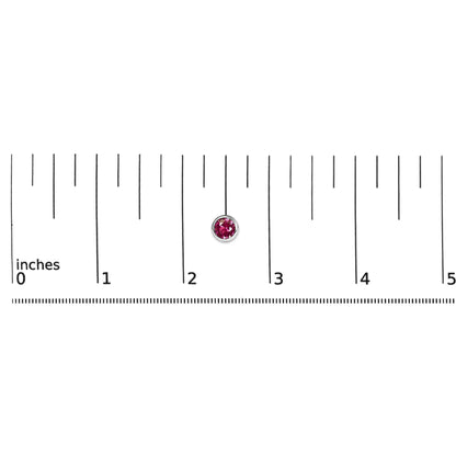 Close-up of a round red gemstone earring with bezel setting in white metal shown on a ruler scale from a top-down angle.