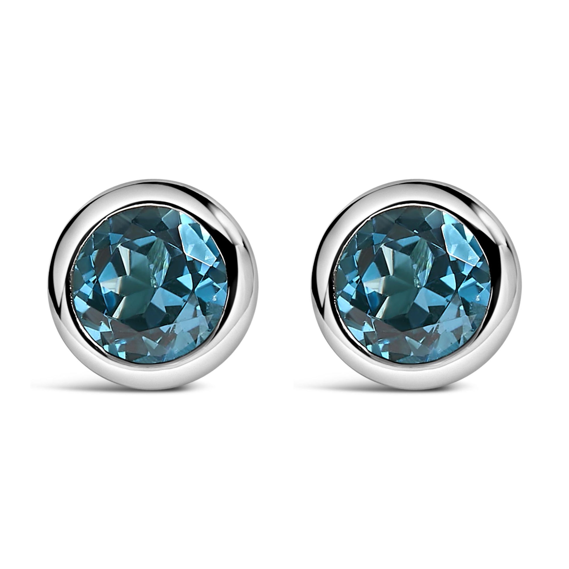 Pair of white metal round bezel-set earrings with round blue gemstones, shown in a front-facing angle.