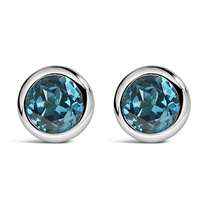 Pair of white metal round bezel-set earrings with round blue gemstones, shown in a front-facing angle.