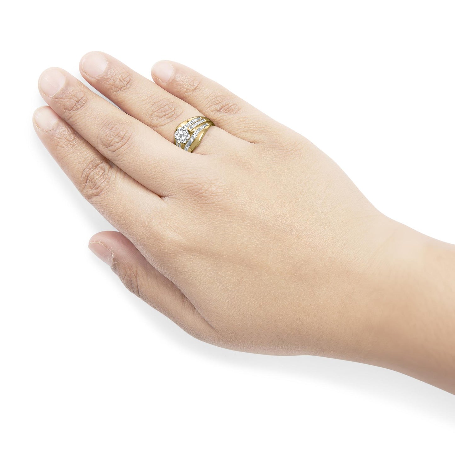 Close-up of a yellow metal ring with round prong-set white gemstones and channel-set white baguette and princess-shaped gemstones, worn on a model's finger, angled top-down view.