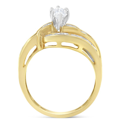 Two-toned ring with a prong-set marquise-shaped white gemstone center, surrounded by channel-set baguette and round white gemstones, shown from a side angle.