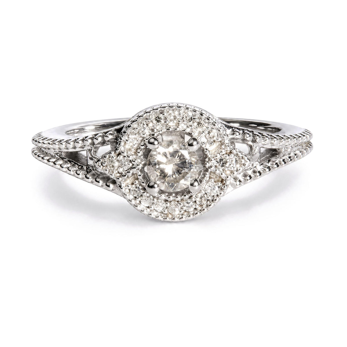 Close-up front view of a white metal ring featuring a central round white gemstone in a prong setting, surrounded by a border of smaller round white gemstones in prong settings, with intricate band detailing.