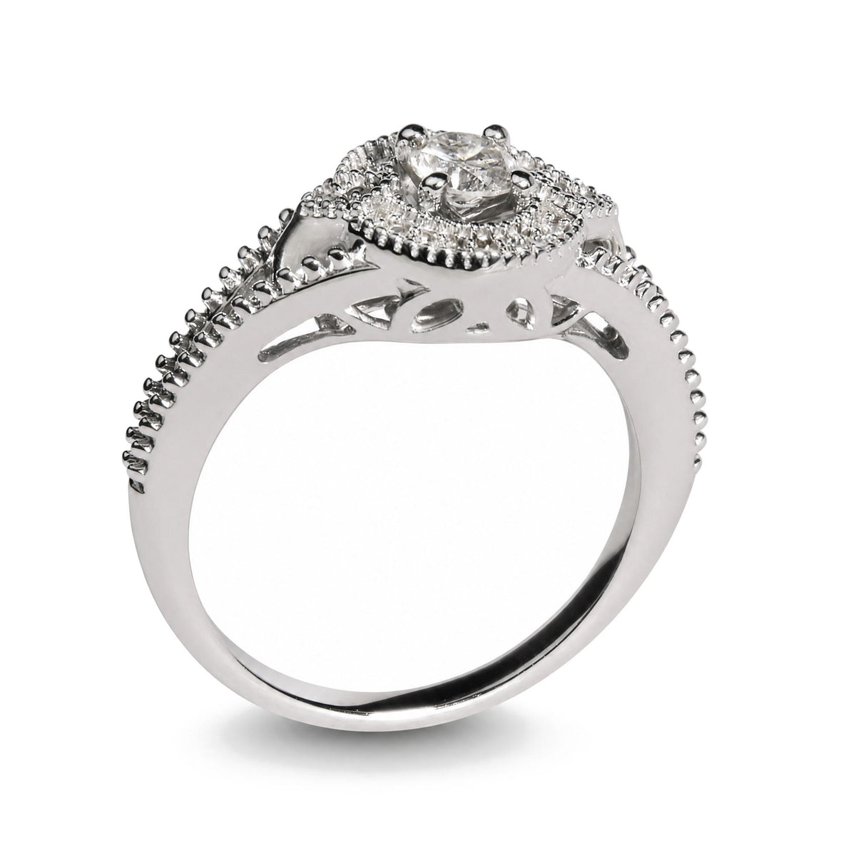 Close-up side angle of a white metal ring featuring a central round white gemstone in a prong setting, surrounded by smaller round white gemstones also in prong settings along the band and around the centerpiece. The band includes decorative cut-out details.