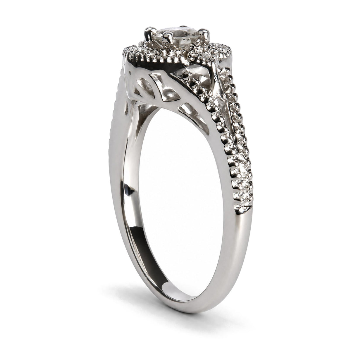 Close-up side angle of a white metal ring with one larger round white gemstone in a prong setting at the top, surrounded and accented by multiple smaller round white gemstones in prong settings along the band.