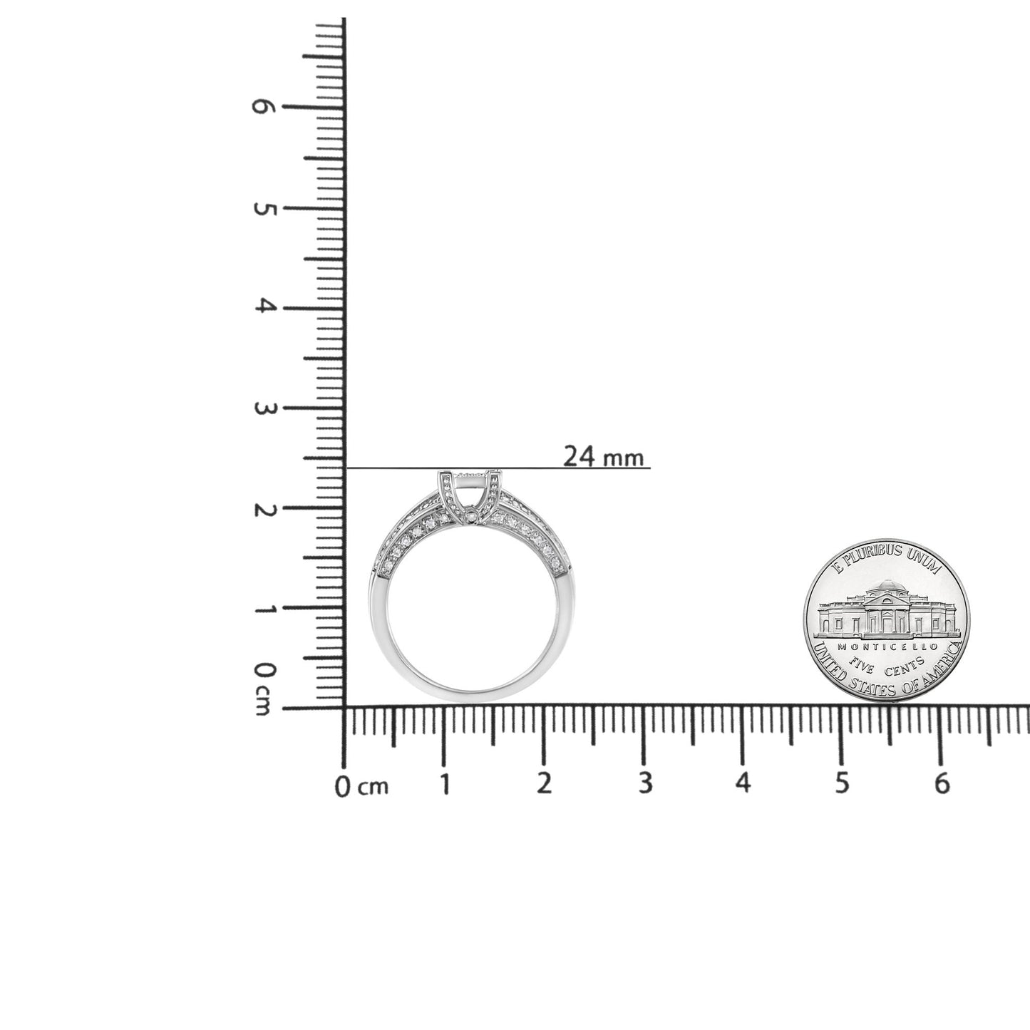 Top view of a white ring with round white gemstones in prong and channel settings, displayed on a ruler for size reference alongside a coin.