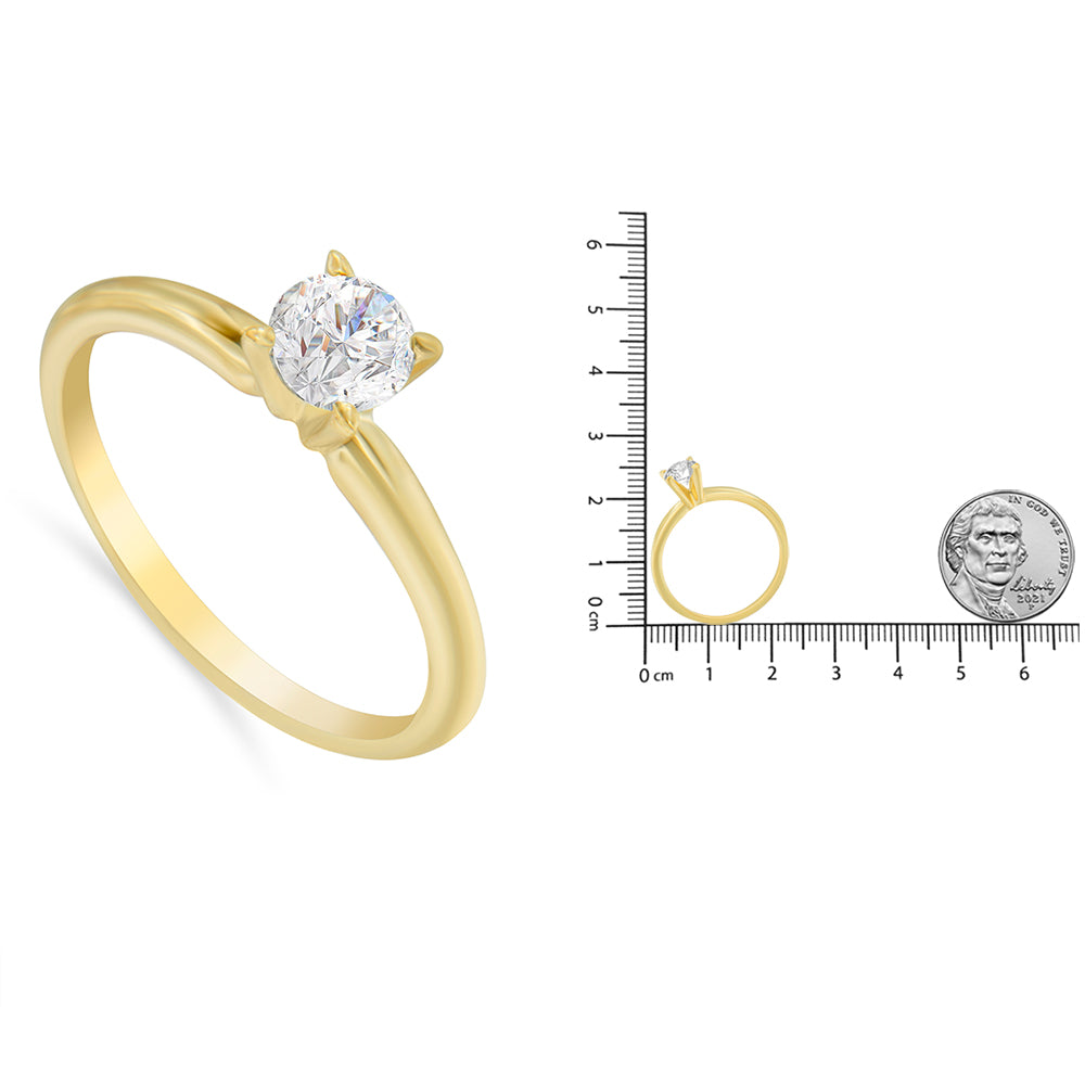Yellow metal ring with a round white gemstone in a prong setting, shown in a close-up angled view and on a ruler for size reference.
