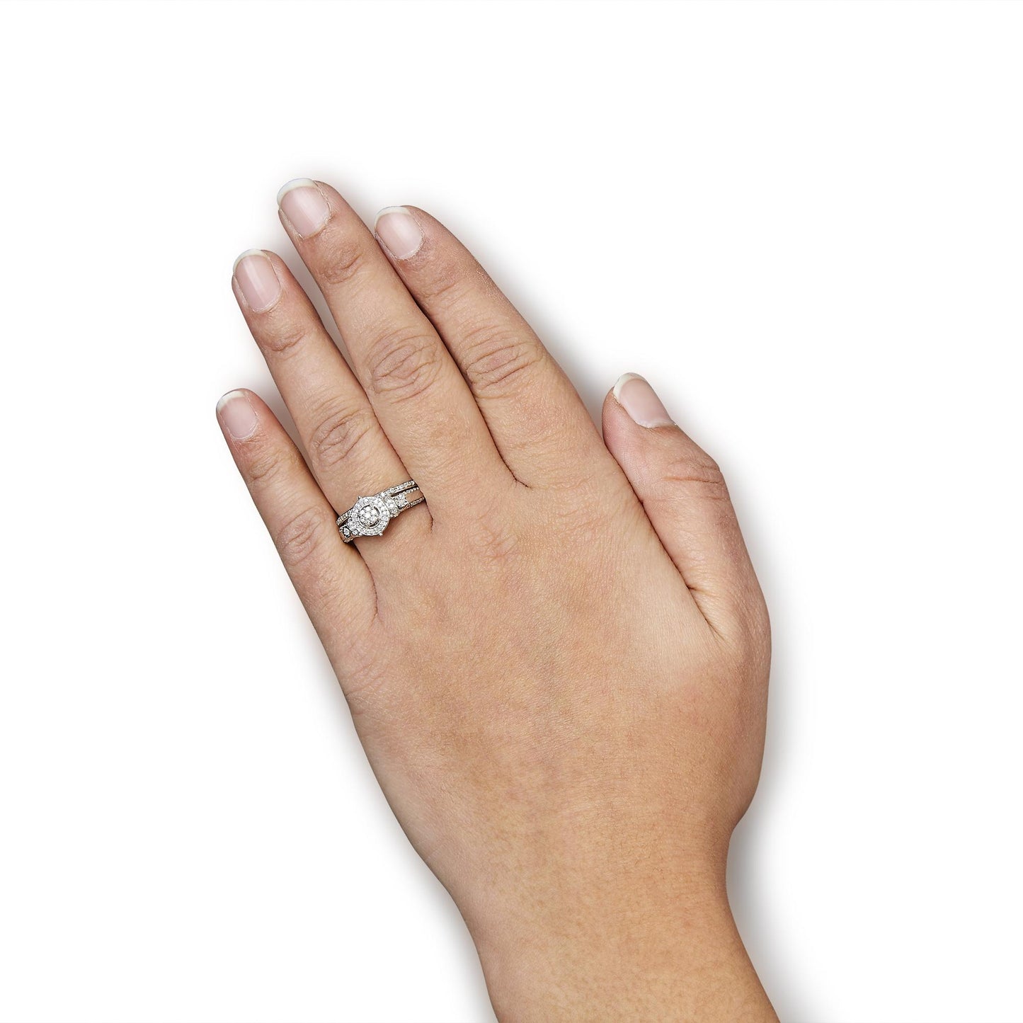 White metal ring with a central round white gemstone in miracle setting, surrounded by smaller round white gemstones in shared prong setting, shown on a model's hand from top angle.