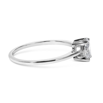 Side view of a white metal ring featuring a single oval-shaped white gemstone in a four-prong setting.