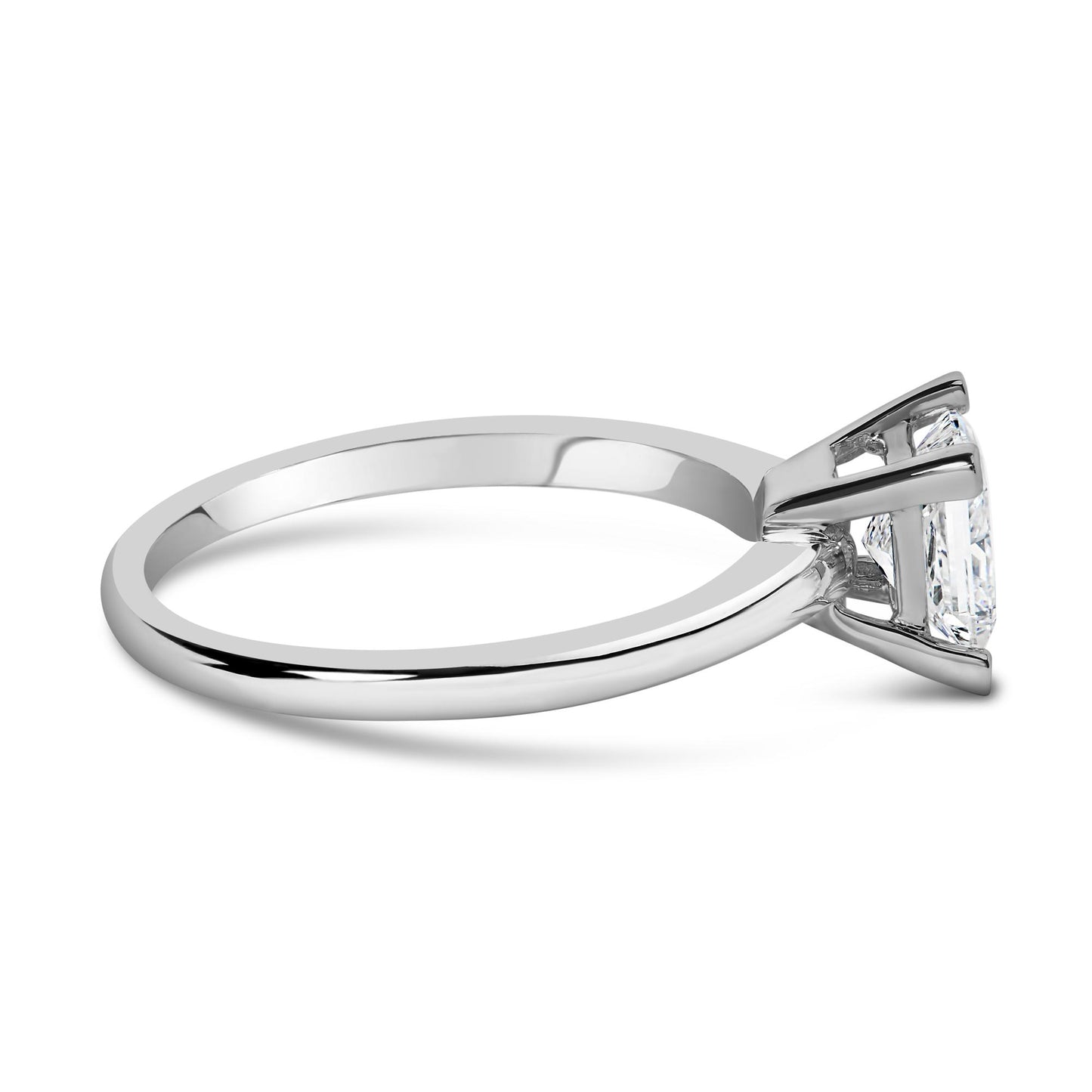 Side view of a white metal ring with a single princess shape white gemstone in a prong setting.
